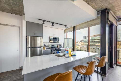 a kitchen with a white counter top and some chairs at New Sleek 2BR - Perfect Blend of Comfort & Style in Chicago in Chicago