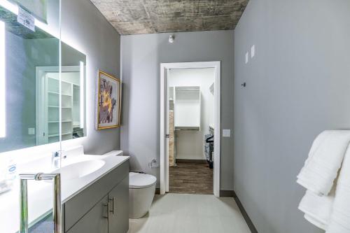a bathroom with a sink and a toilet and a mirror at New Sleek 2BR - Perfect Blend of Comfort & Style in Chicago in Chicago