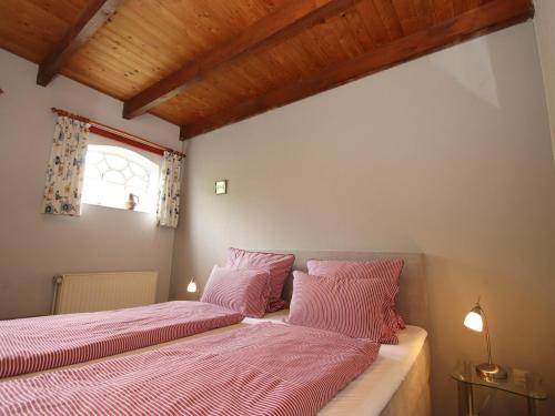 2 letti in una camera con cuscini rosa di Ferienwohnungen in Strackholt a Strackholt