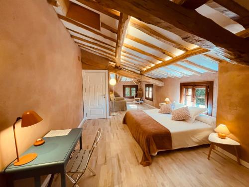 a bedroom with a bed and a desk in a room at CASA DEL AGUA - La Rioja in Santa Coloma