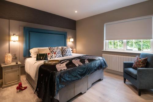a bedroom with a large bed and a chair at Robeen House in Killarney