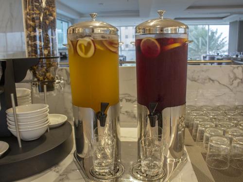 two glass vases sitting on a table with drinks at Veliton Hotel in Al Khobar