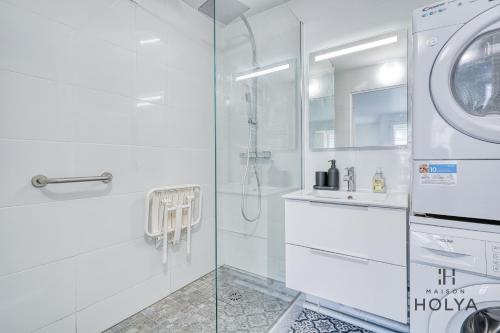 une salle de bain blanche avec une machine à laver et un lavabo dans l'établissement Le Sanctuaire - À Versailles - 341B, à Versailles
