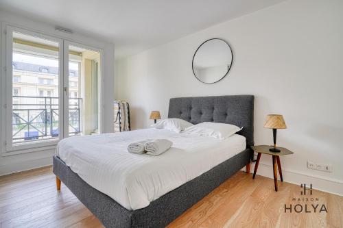 une chambre avec un grand lit avec un miroir au mur dans l'établissement Le Sanctuaire - À Versailles - 341B, à Versailles