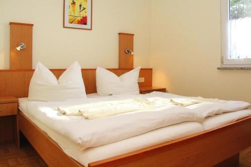 a large white bed with white pillows on it at Seepark Heidenholz, Plau am See in Plau am See