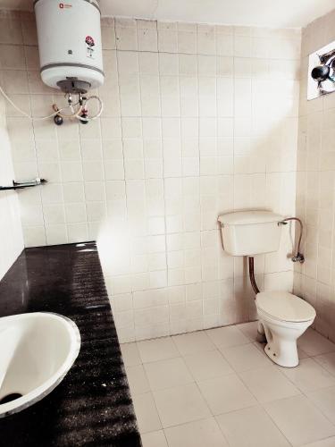 a bathroom with a toilet and a sink at Shantiniketan 4BHK Comfortable Family Stay in Ayodhya in Ayodhya