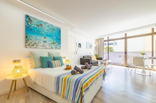 a bedroom with a bed with a painting on the wall at HORIZON VACATION HOME - Guest House Gran Canaria in San Bartolomé de Tirajana