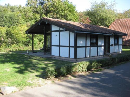 a small white and black building on the side of a road at Holiday Home in Germany with Idyllic Nature in Berneburg