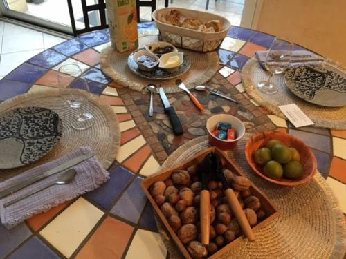 une table avec des assiettes et des bols de nourriture dans l'établissement Villa Bellevue chambre d'hôtes, à Siorac-en-Périgord