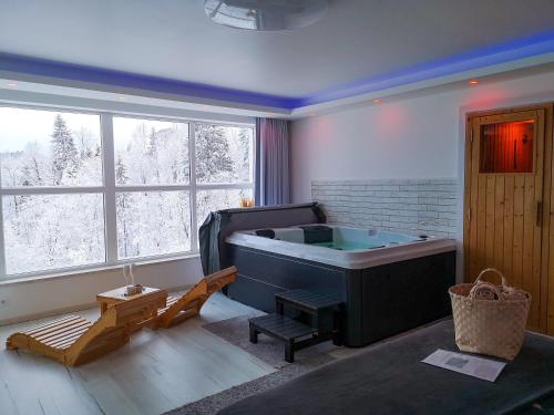 a room with a bath tub in a room with windows at Wellness pod zvezdami, Maribor - PRIVATE in Maribor
