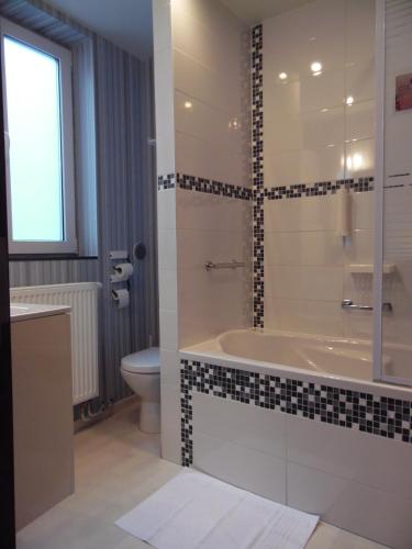 a bathroom with a tub and a toilet at Vakantielogies Cathedral in Ghent