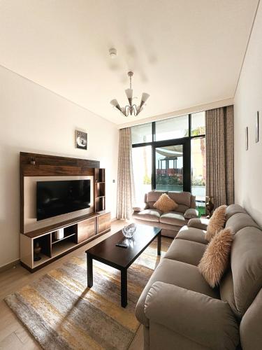 a living room with a couch and a tv at VESTA - Dubai Residence in Dubai
