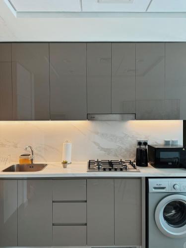 a kitchen with a stove top oven next to a sink at VESTA - Dubai Residence in Dubai