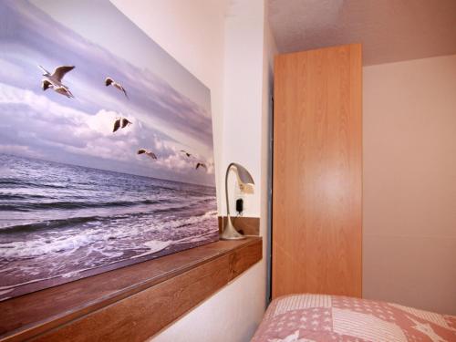 a bedroom with a painting of the ocean at Wohnung in Boltenhagen am Ostseestrand in Boltenhagen