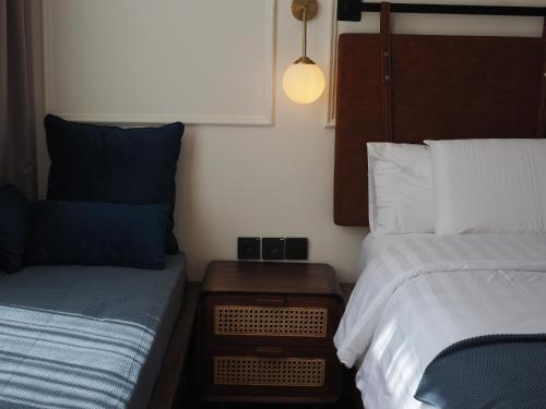 a small bedroom with two beds and a nightstand with a bed sidx sidx sidx at Blue Marlin Dive Boutique Hotel in Kuta Lombok