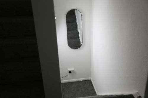 a room with a mirror and a white wall at 3BR Luxury Stay Near Billing Aquadrome - Elegant 3-Bedrooms One-and-Half Bathrooms Home - Sleeps 8 - Free Parking and Complimentary Access to Billing Aquadrome Holiday Village in Northampton