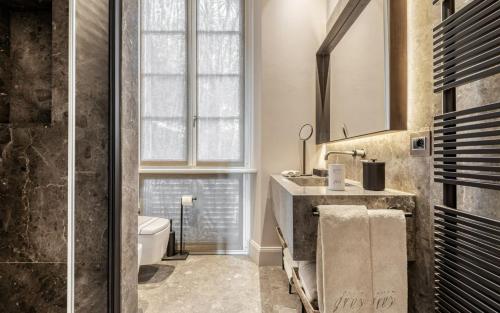 a bathroom with a sink and a toilet and a window at Villa Grey in Forte dei Marmi