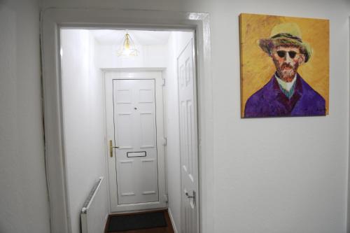 a painting of a man in a hat on a wall at 3BR Luxury Stay Near Billing Aquadrome - Elegant 3-Bedrooms One-and-Half Bathrooms Home - Sleeps 8 - Free Parking and Complimentary Access to Billing Aquadrome Holiday Village in Northampton