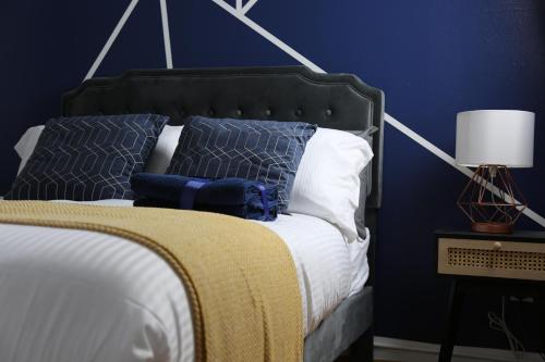 a bedroom with a bed with blue walls at 3BR Luxury Stay Near Billing Aquadrome - Elegant 3-Bedrooms One-and-Half Bathrooms Home - Sleeps 8 - Free Parking and Complimentary Access to Billing Aquadrome Holiday Village in Northampton