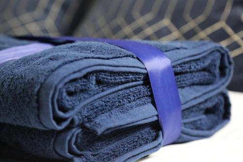 a stack of towels sitting on top of a bed at 3BR Luxury Stay Near Billing Aquadrome - Elegant 3-Bedrooms One-and-Half Bathrooms Home - Sleeps 8 - Free Parking and Complimentary Access to Billing Aquadrome Holiday Village in Northampton