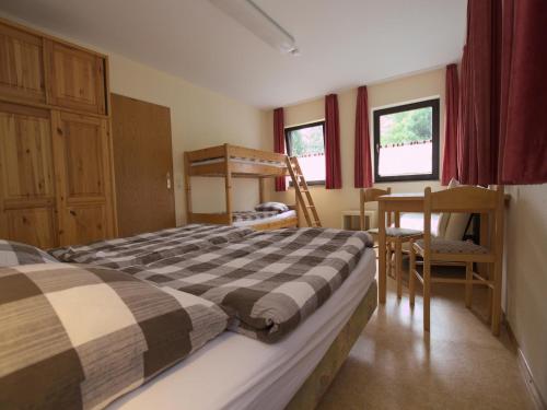 a bedroom with a bed and a desk and a chair at Ferienwohnung im Haus Schiefertal, Wieda in Wieda