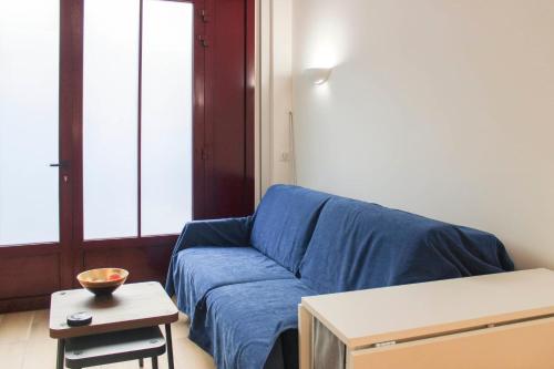 un salon avec un canapé bleu et une table dans l'établissement Charming apartment near Buttes-Chaumont, à Paris