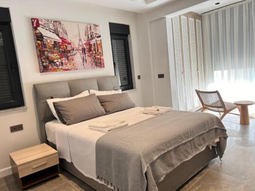 a bedroom with a large bed and a chair at Leos Apartments Apart2 in Side