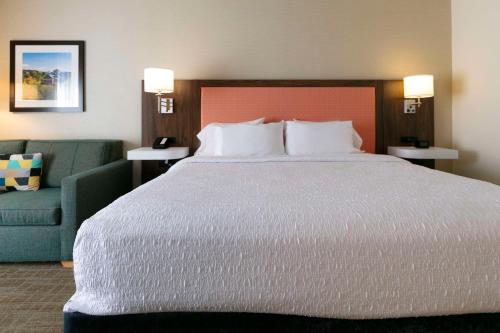 a large bed in a hotel room with a couch at Hampton Inn Scranton at Montage Mountain in Scranton