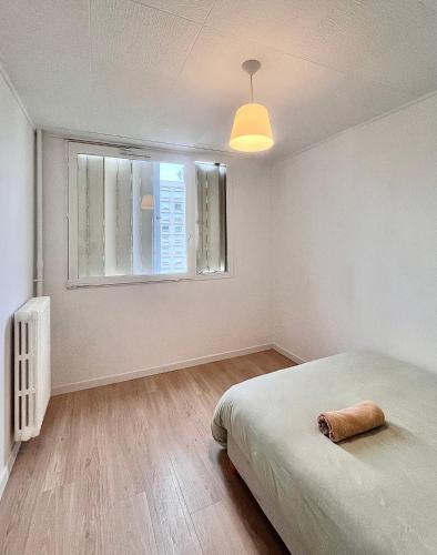 une chambre blanche avec un lit et une fenêtre dans l'établissement Apparemment spacieux T5, à Lyon