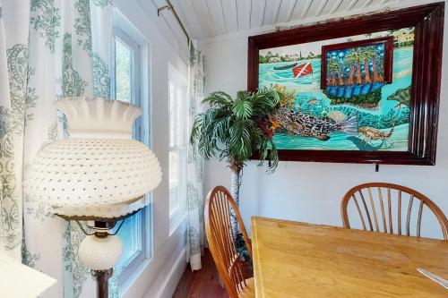 a dining room with a table and a painting on the wall at Diver Down Cottage in Carrabelle