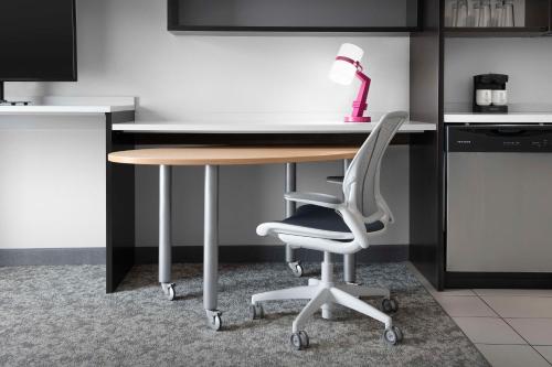 a desk with a chair and a lamp on it at Home2 Suites by Hilton Greensboro Airport, NC in Greensboro