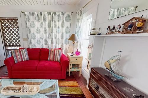 a living room with a red couch and a table at Diver Down Cottage in Carrabelle