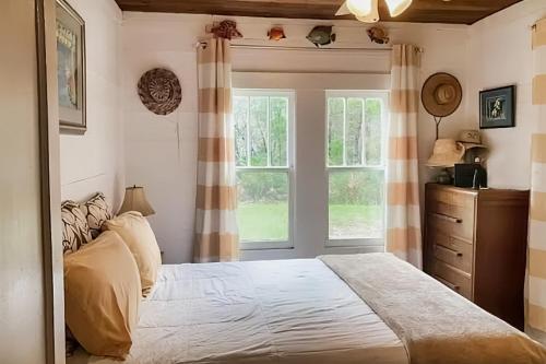 a bedroom with a large bed and a window at Diver Down Cottage in Carrabelle