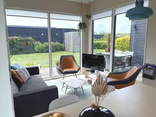 a living room with a couch and chairs and a table at Nieuw Noorderland - Ecohuisjes Terschelling in Midsland