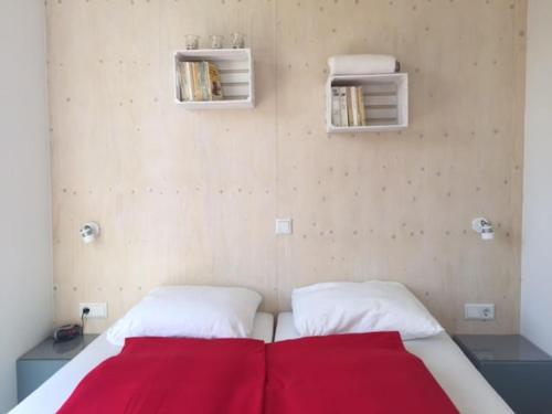 a bedroom with a bed with a red blanket at Nieuw Noorderland - Ecohuisjes Terschelling in Midsland