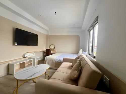 una camera d'albergo con un divano e un letto di Hoang Thang 1 Hotel Da Lat City a Da Lat