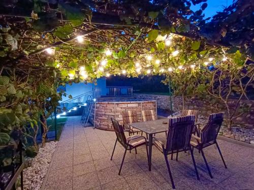 a table and chairs under a pergola with lights at Wellness pod zvezdami, Maribor - PRIVATE in Maribor