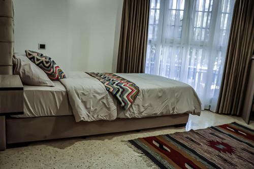 a bedroom with a bed and a large window at Celestia Boutique Inn - Boutique Stay Overlooking Jerash Ruins in Jerash