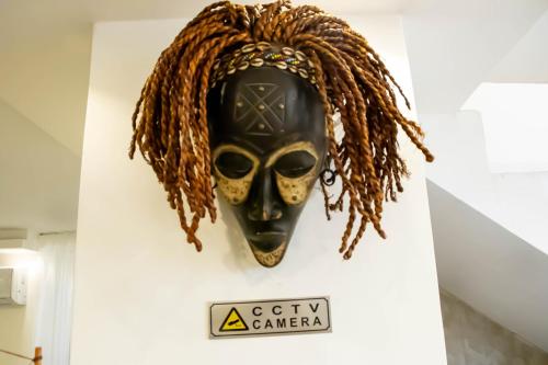 a mask hanging on a wall with a sign at Celestia Boutique Inn - Boutique Stay Overlooking Jerash Ruins in Jerash