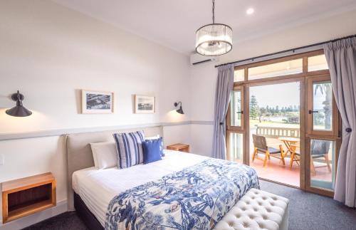a bedroom with a bed and a sliding glass door at Bermagui Beach Hotel in Bermagui