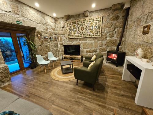 a living room with a stone wall at Quinta da Casa dos Santos - Inside Gerês in Geres