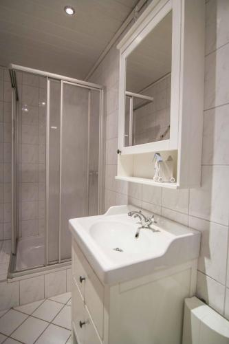 a white bathroom with a sink and a shower at Monopol 306 in Wangerooge
