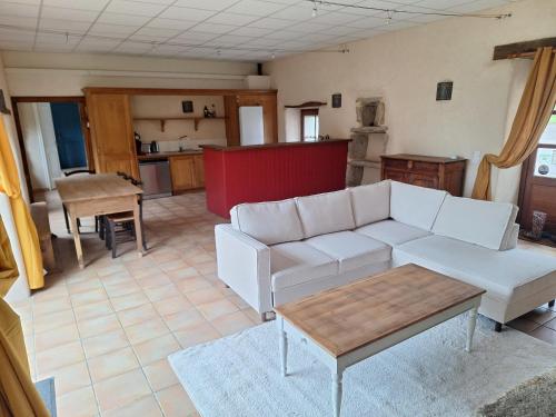 a living room with a white couch and a table at Domaine de Bobehec - Gîte de groupe, chambres & Salle - jusqu'à 23 couchages - Morbihan proche Vannes et plages in La Vraie-Croix