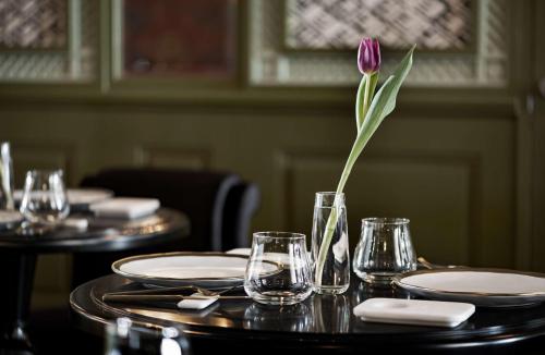 a purple flower in a vase on a table at NH Collection Colón Valencia in Valencia