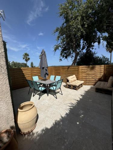 un patio avec une table, des chaises et un parasol dans l'établissement La Maison Provencale, à Cogolin