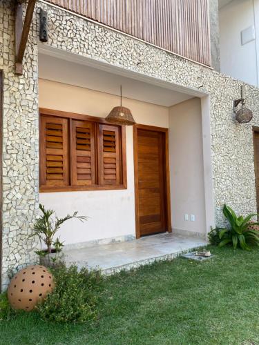 a front door of a house with wooden doors at Casa Pitanga Flat in Jericoacoara