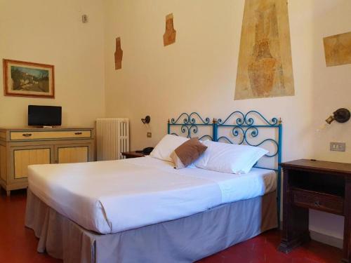 a bedroom with a large white bed and a desk at Hotel Annalena in Florence