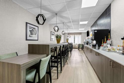 a dining room with a long bar with chairs at Clarion Pointe Franklin - Nashville Area in Franklin