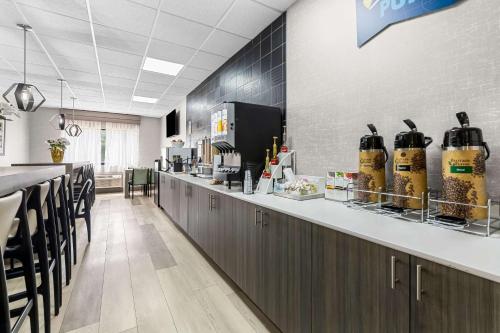 a restaurant with a bar with black chairs and a counter at Clarion Pointe Franklin - Nashville Area in Franklin