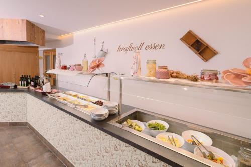 a kitchen with a buffet line with food at Der Paternwirt in Maria Luggau